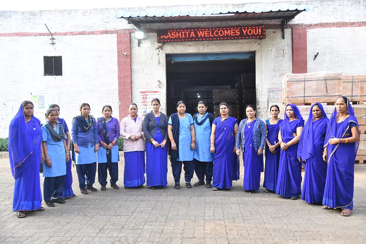 The production team outside the Jaipur works, beneath the plant's Aashita Welcomes You sign